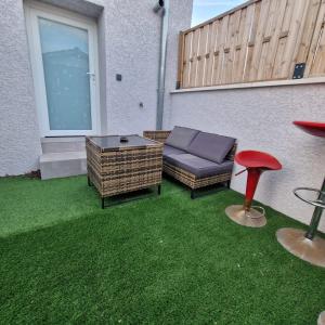 un patio con sofá, mesa y taburete en Expérience des sens, en Grézieu-la-Varenne