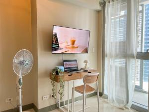 une pièce avec un bureau et une télévision au mur dans l'établissement Luxury BGC Condo Near Uptown,Grand Hyatt #upt219k, à Manille