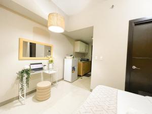 ein kleines Zimmer mit Schreibtisch und Kühlschrank in der Unterkunft Prime BGC 1BR Near Mitsukoshi Mall #upt16m in Manila