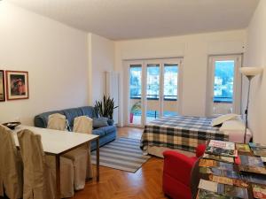 a living room with a blue couch and a bed at Lakefront 15 in Omegna