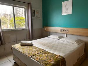 a bedroom with a bed in a room with a window at Villa Mar Boa Viagem in Recife
