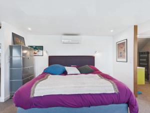 una camera da letto con un grande letto con coperte e cuscini colorati di Superbe villa à Plouguerneau les pieds dans l'eau a Plouguerneau