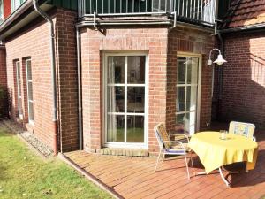 un patio con mesa y sillas en un edificio de ladrillo en 'Edes Huus', en Langeoog