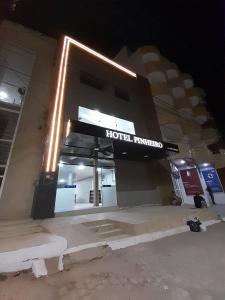 a hotel entrance with a sign on it at night at Hotel Pinheiros in Nossa Senhora da Glória