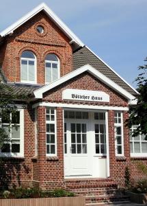 een bakstenen gebouw met een bord dat abonnee suites leest bij Ferienwohnung 1 im 'BÖTTCHER HUUS' in Langeoog