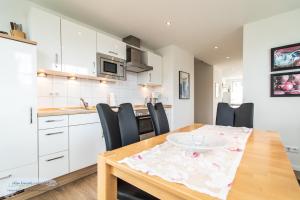 een keuken en eetkamer met een tafel en stoelen bij Ferienwohnung 1 im 'BÖTTCHER HUUS' in Langeoog +3 foto's