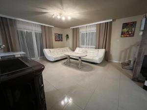 a living room with a white couch and a table at Sands Dom Szteklin in Szteklin