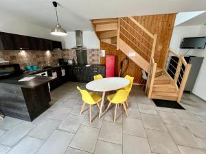 a kitchen with a table and some yellow chairs at Chez Marcel - Maison 3 chambres in Lussac-les-Châteaux