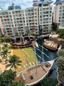 a large boat in a river with tall buildings at Accommodation with waterpark in Pattaya South