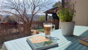 a table with a book and a glass of coffee at אל גינת אגוז in Neve Ilan