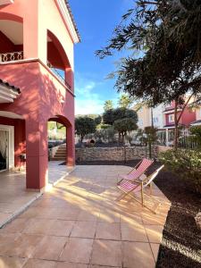 a pair of chairs sitting on a patio at Planta baja con gran terraza y jardín Altaona golf in Murcia