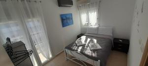 Un dormitorio pequeño con una cama y una ventana. en Evi's Apartment, en Perea