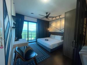 a bedroom with a bed and a chair and a window at Almas suites puteri harbour by Hairis in Iskandar Puteri +75 photos