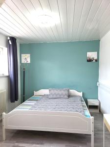 a bedroom with a bed with a blue wall at Charlotte House Heidelberg in Dossenheim