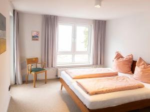 a bedroom with a bed and a window and a chair at Apartment Blaumuschel - LUB108 by Interhome in Lubmin