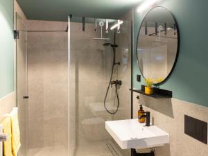 a bathroom with a shower and a sink and a mirror at Apartment Blaumuschel - LUB108 by Interhome in Lubmin