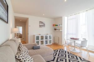 a living room with a couch and a table at Apartamento Holidea Parque las Llamas in Santander