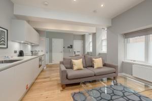 a living room with a couch and a kitchen at Destiny Scotland Apartments at Canning Street Lane in Edinburgh