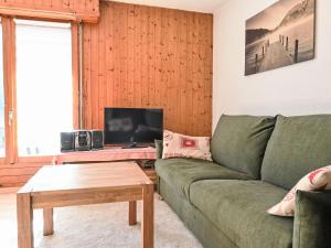 a living room with a green couch and a tv at Apartment Jorasse A 1 by Interhome in Ovronnaz