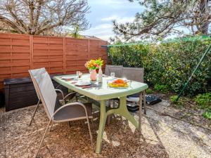 d'une table de patio avec des chaises et des fleurs. dans l'établissement Apartment Les Landaises-5 by Interhome, à Mimizan-Plage 26 autres photos