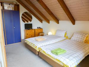 a bedroom with two beds and a television in it at Apartment Altstadt Loft by Interhome in Interlaken