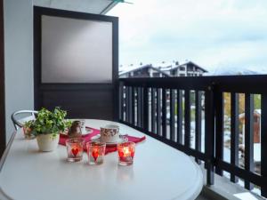 a table on a balcony with three candles and a plate of food at Apartment Arnica 16 by Interhome in Nendaz +27 photos