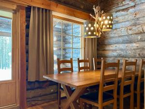 a dining room with a wooden table and chairs at Holiday Home Sallan savu a by Interhome in Salla