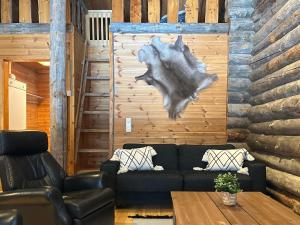 a living room with a couch and a wooden wall at Holiday Home Sallan savu a by Interhome in Salla +14 photos