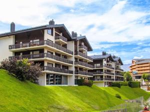 an apartment building on a hill with green grass at Apartment Arnica 16 by Interhome in Nendaz