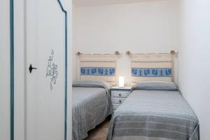 una camera da letto con due letti e uno specchio di Marina Maria a Murta Maria