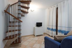 un soggiorno con scala e divano blu di Marina Maria a Murta Maria
