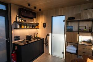 a small kitchen with a white refrigerator and a counter at Glacial Glass Cabin in Hella