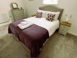 a bedroom with a bed with two towels on it at 29 Malthouse Alnwick Holiday Apartment in Alnwick