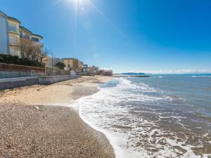 サン·ヴィンチェンツォにあるApartment Mediterraneo by Interhomeの晴れた日には海と建物のあるビーチ
