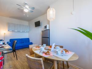 a living room with a table and a blue couch at Apartment Mediterraneo by Interhome in San Vincenzo