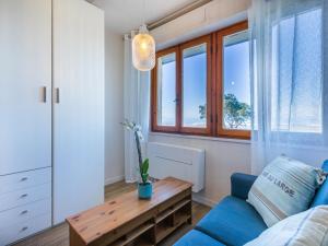 サン·ヴィンチェンツォにあるApartment Mediterraneo by Interhomeのリビングルーム(青いソファ、木製テーブル付)