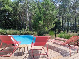 a group of chairs sitting next to a pool at Villa Holidays Ocean in Messanges