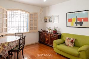 a living room with a green couch and a table at Elegante Apto a 260m da Praia Grande BTI003 in Ubatuba