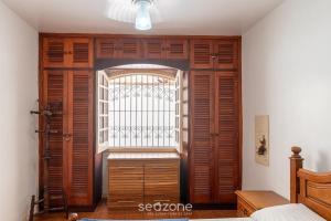 a room with a window and a wooden door at Elegante Apto a 260m da Praia Grande BTI003 in Ubatuba