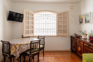 a dining room with a table and a window at Elegante Apto a 260m da Praia Grande BTI003 in Ubatuba