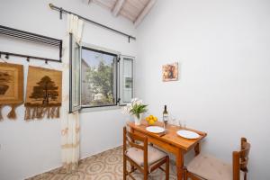 a dining room with a table and a window at Aimilia Cottage in Longos +15 photos