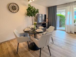 a dining room with a black table and white chairs at FeWo Nordstern - Schillig in Wangerland