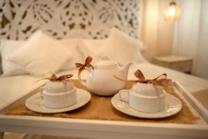 a tray with two tea cups and saucers on a bed at Casa Pavò in Bari