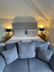 a bedroom with a bed and a couch with pillows at Haversham House - Adults Only in Llandudno
