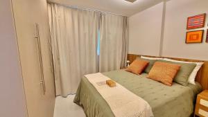 a bedroom with a bed with two pillows and a window at Apartment JC 903: Jardim Camburi. Vitória- E.S. in Carapina +13 photos