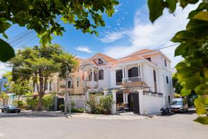 a large white house with a car parked in front of it at Hoàng My Villa Bãi Sau Vũng Tàu in Vung Tau