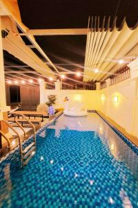 a large swimming pool with a tub in the middle at Hoàng My Villa Bãi Sau Vũng Tàu in Vung Tau