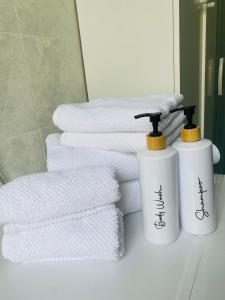two white towels are sitting next to a pile of towels at Ca di nonni in Ortovero