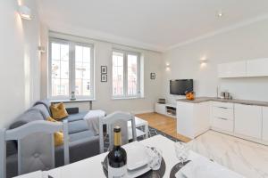 Una cocina y una sala de estar con un sofá y una mesa. en YOURAPART Piwna Luxury Apartment, en Gdansk