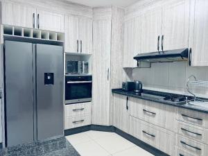 a kitchen with a stainless steel refrigerator and cabinets at LOR Homes in Gaborone